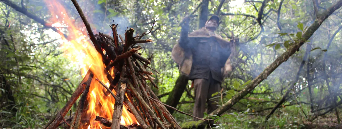 Elder Samuel beside the fire he built during a demonstration of traditional fire-making steps